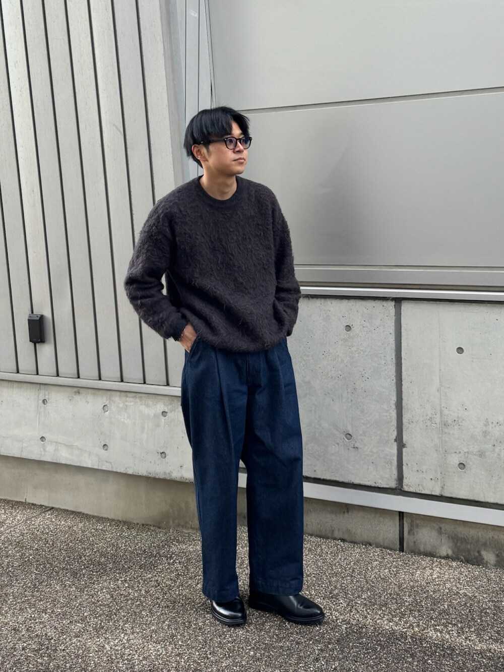 パープル系のニット/セーター、ブラック系のブーツ、ブルー系のデニムパンツを着用したメンズの冬コーディネートの2枚目の写真