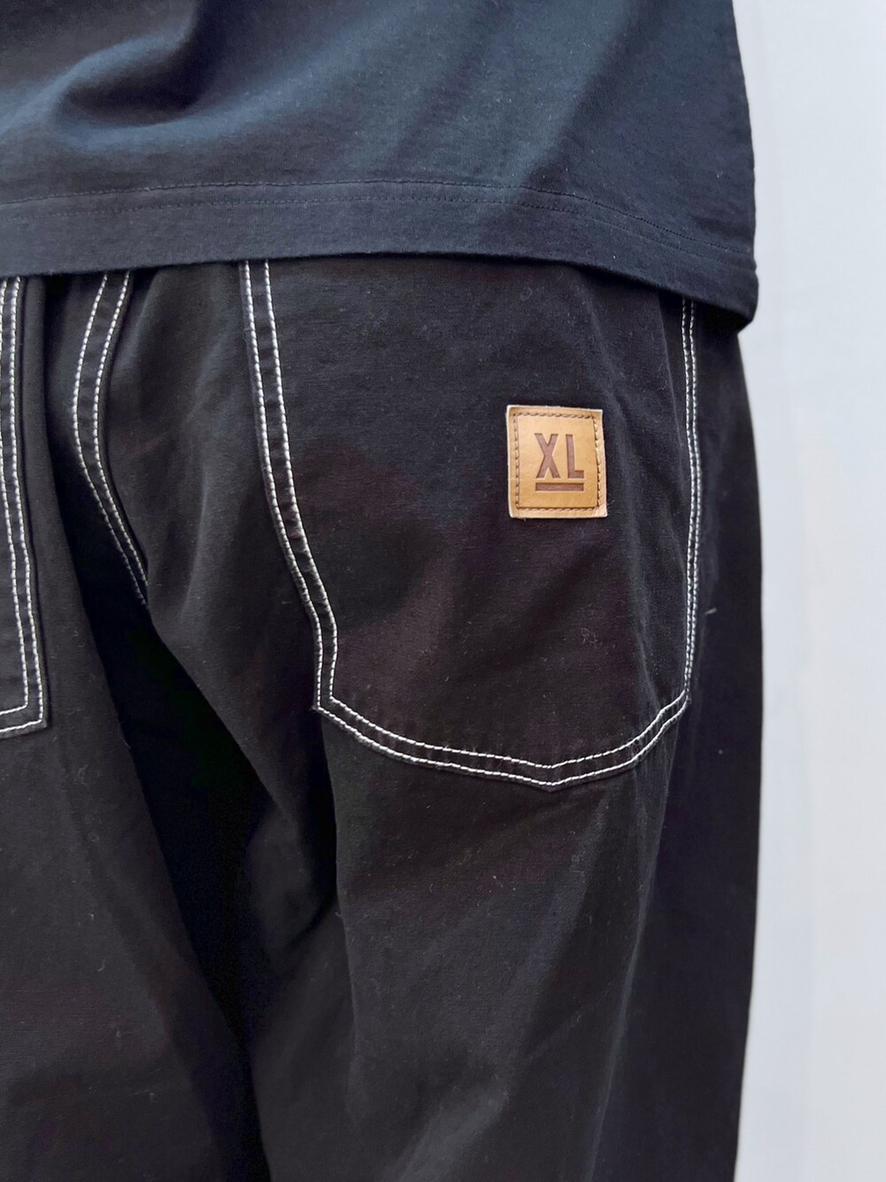 ブラック系のTシャツ/カットソー、ブラック系のその他パンツ、ホワイト系のキャップを着用したレディースの春コーディネートの5枚目の写真