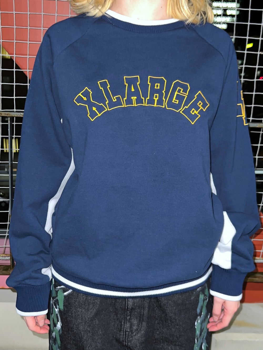 ブルー系のスウェット、ブルー系のデニムパンツ、ブラック系のキャップを着用したレディースの冬コーディネートの2枚目の写真