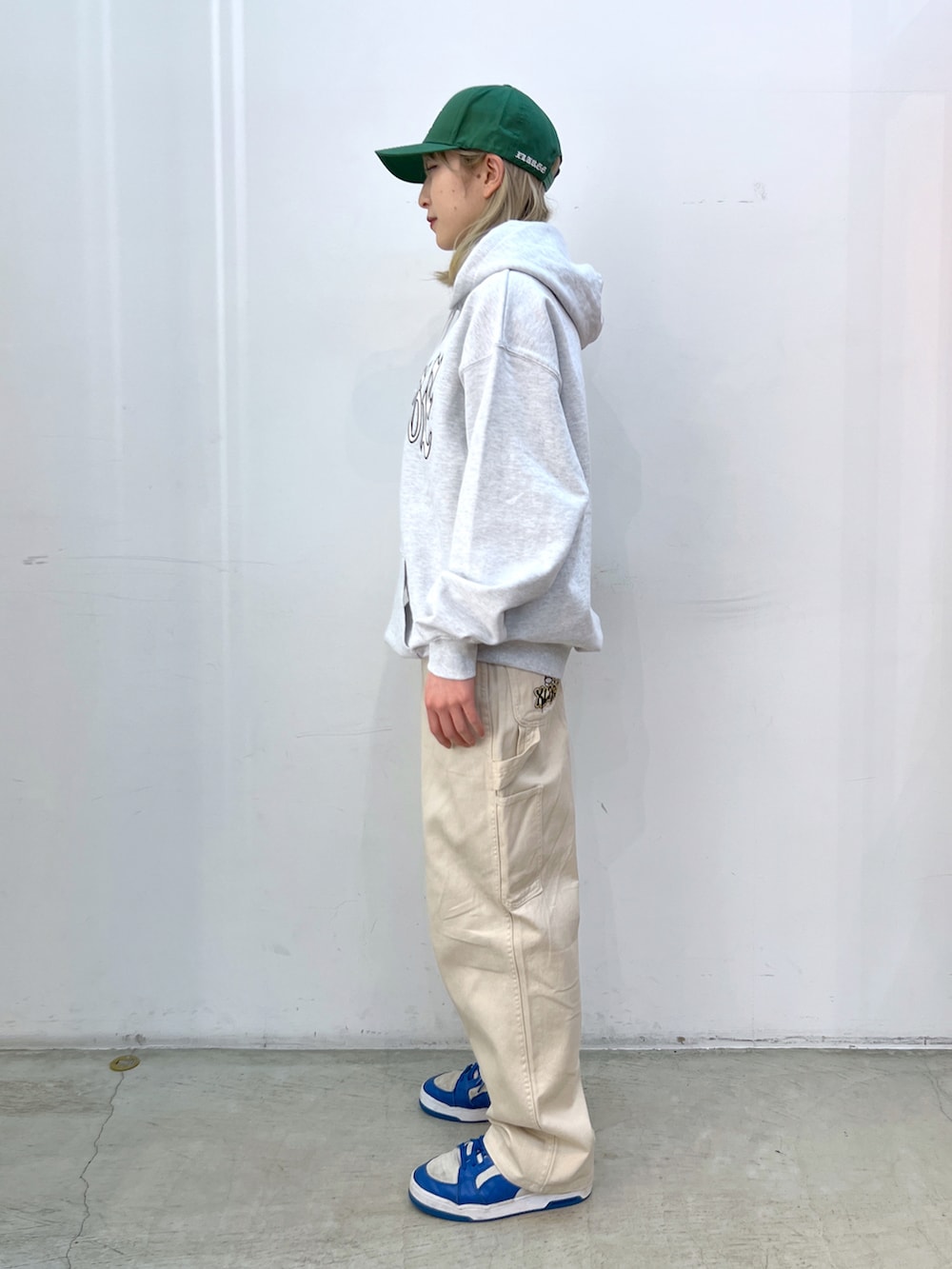 グレー系のパーカー、ベージュ系のその他パンツ、グリーン系のキャップを着用したレディースの春コーディネートの2枚目の写真