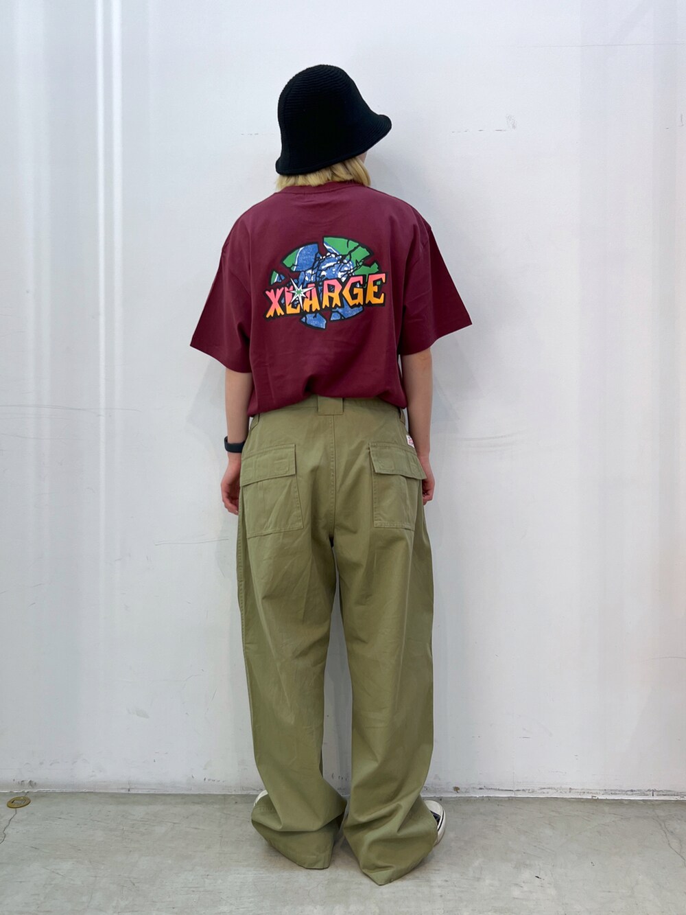 レッド系のTシャツ/カットソー、グレー系のその他パンツ、ブラック系のハットを着用したレディースの夏コーディネートの2枚目の写真