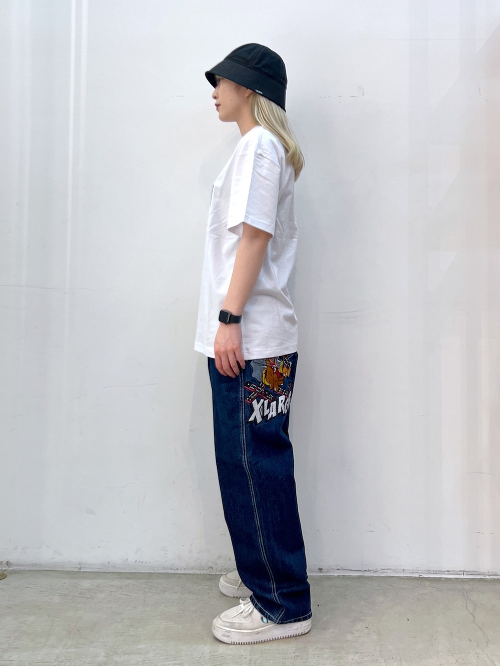 ホワイト系のTシャツ/カットソー、ブルー系のデニムパンツを着用したレディースの秋コーディネートの4枚目の写真
