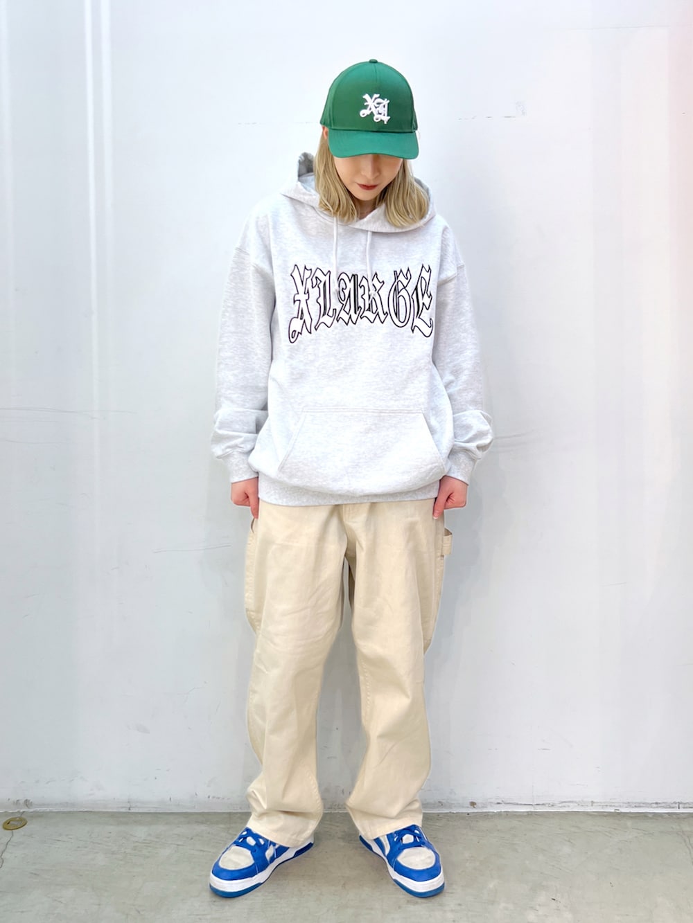グレー系のパーカー、ベージュ系のその他パンツ、グリーン系のキャップを着用したレディースの春コーディネートの3枚目の写真