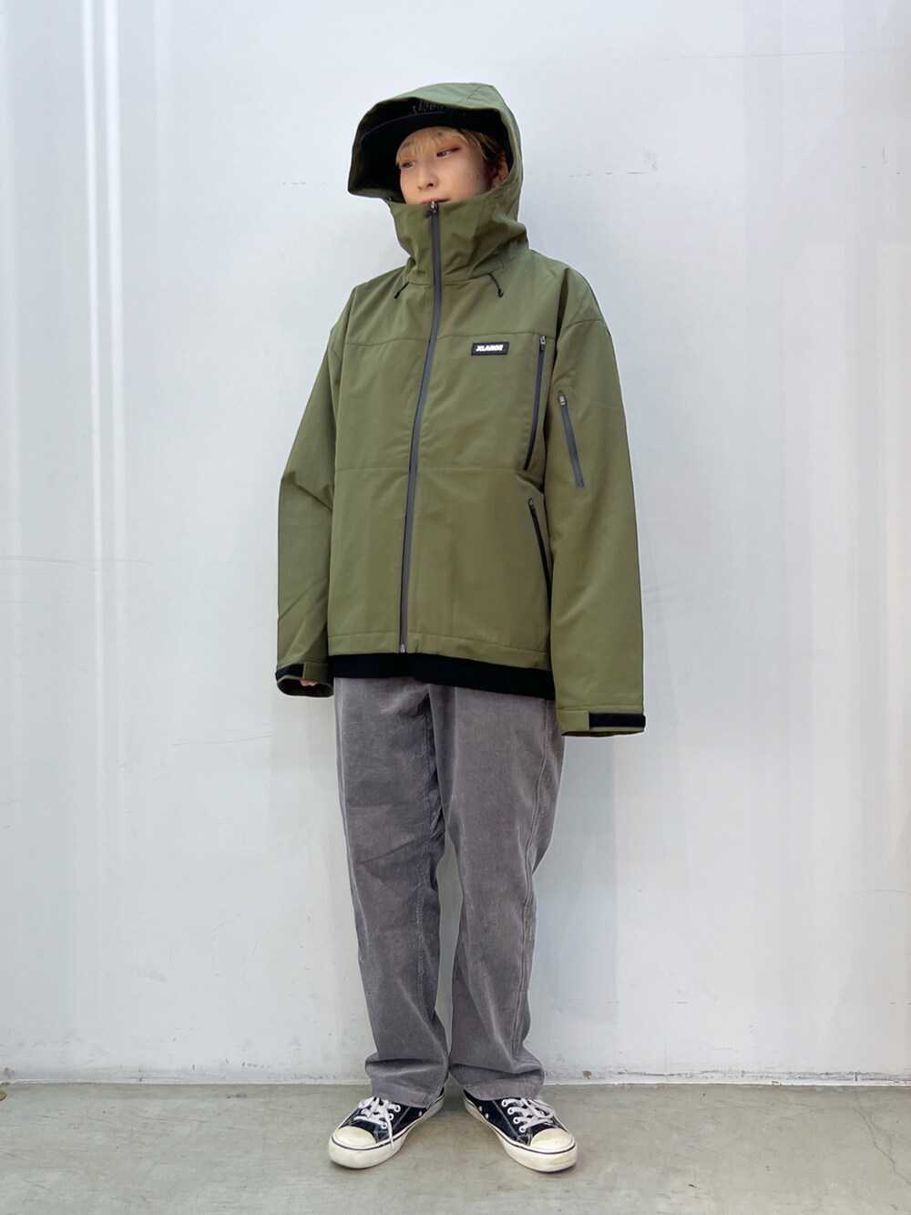 ブラック系のニット/セーター、グリーン系のマウンテンパーカー、グレー系のその他パンツを着用したレディースの秋コーディネートの3枚目の写真