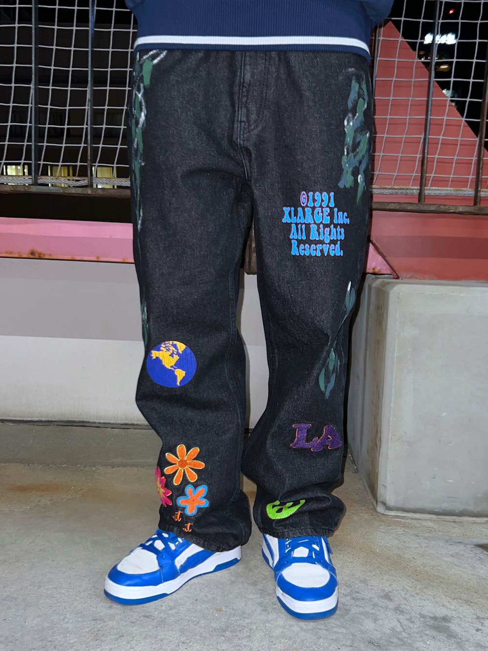 ブルー系のスウェット、ブルー系のデニムパンツ、ブラック系のキャップを着用したレディースの冬コーディネートの3枚目の写真