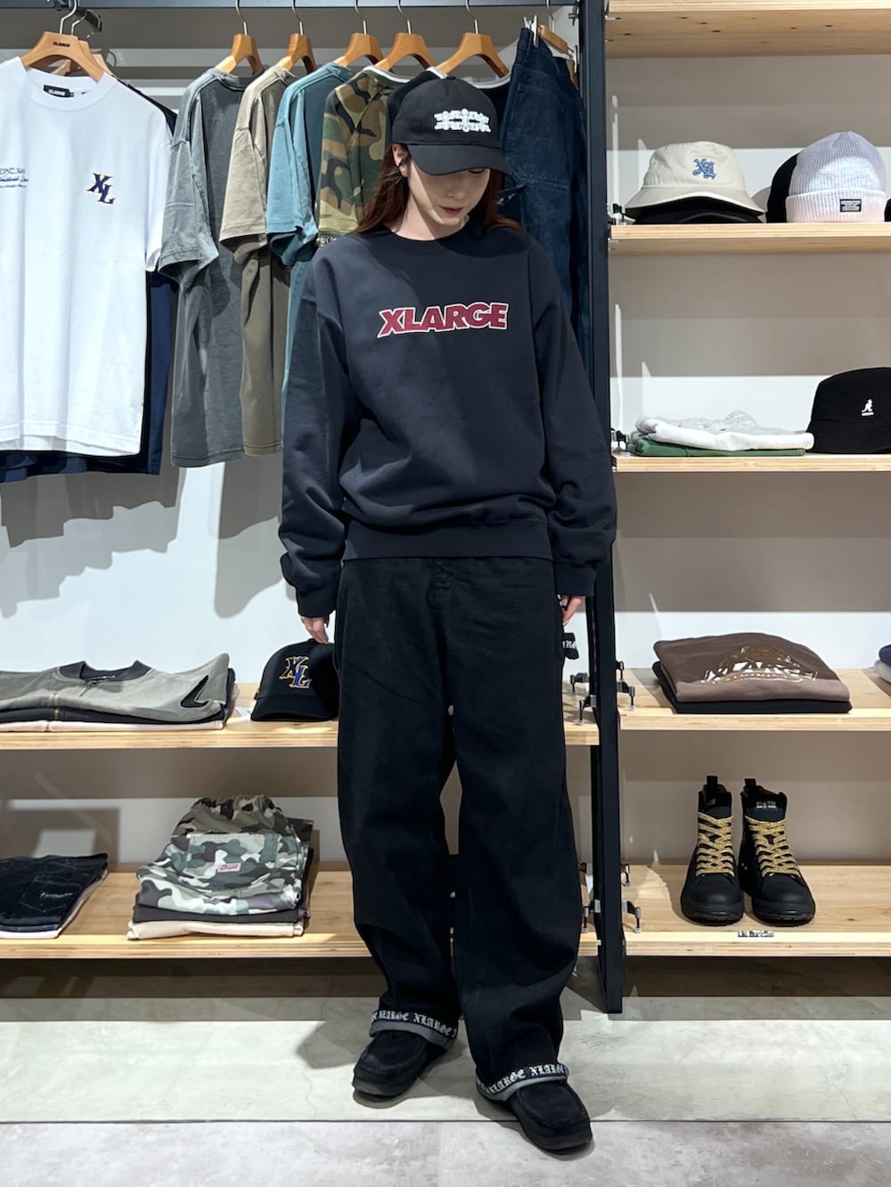 ブラック系のスウェット、ブラック系のデニムパンツ、ブラック系のキャップを着用したレディースの秋コーディネートの3枚目の写真