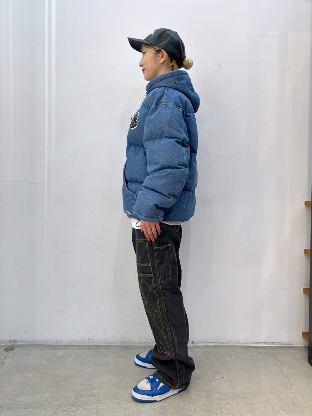 ブルー系のブルゾン、ホワイト系のTシャツ/カットソー、ブラック系のデニムパンツを着用したレディースの冬コーディネートの2枚目の写真