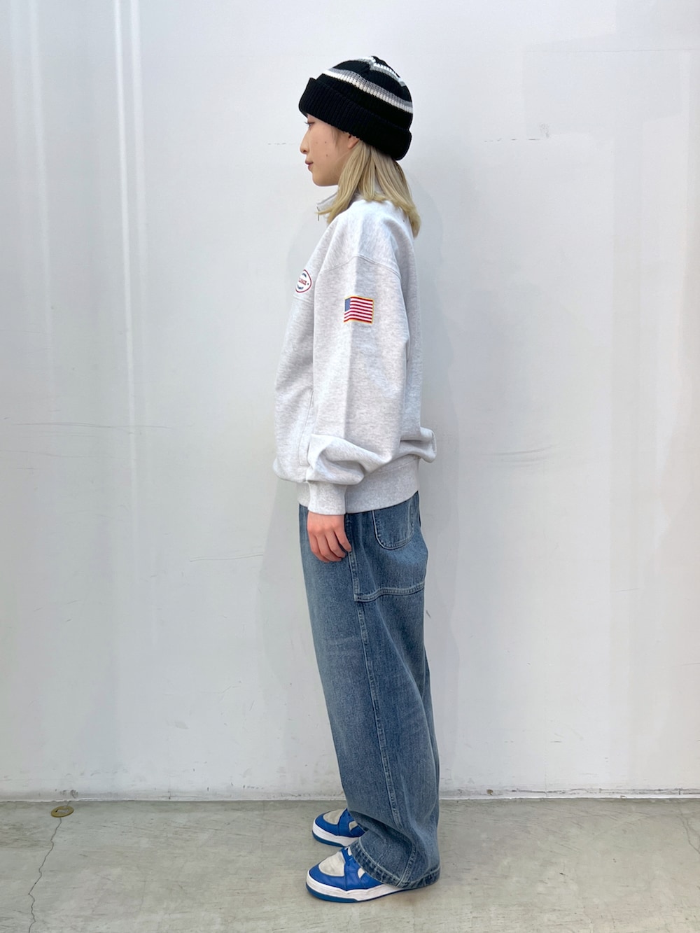 グレー系のスウェット、ブルー系のその他パンツ、ブラック系のニットキャップ/ビーニーを着用したレディースの春コーディネートの2枚目の写真