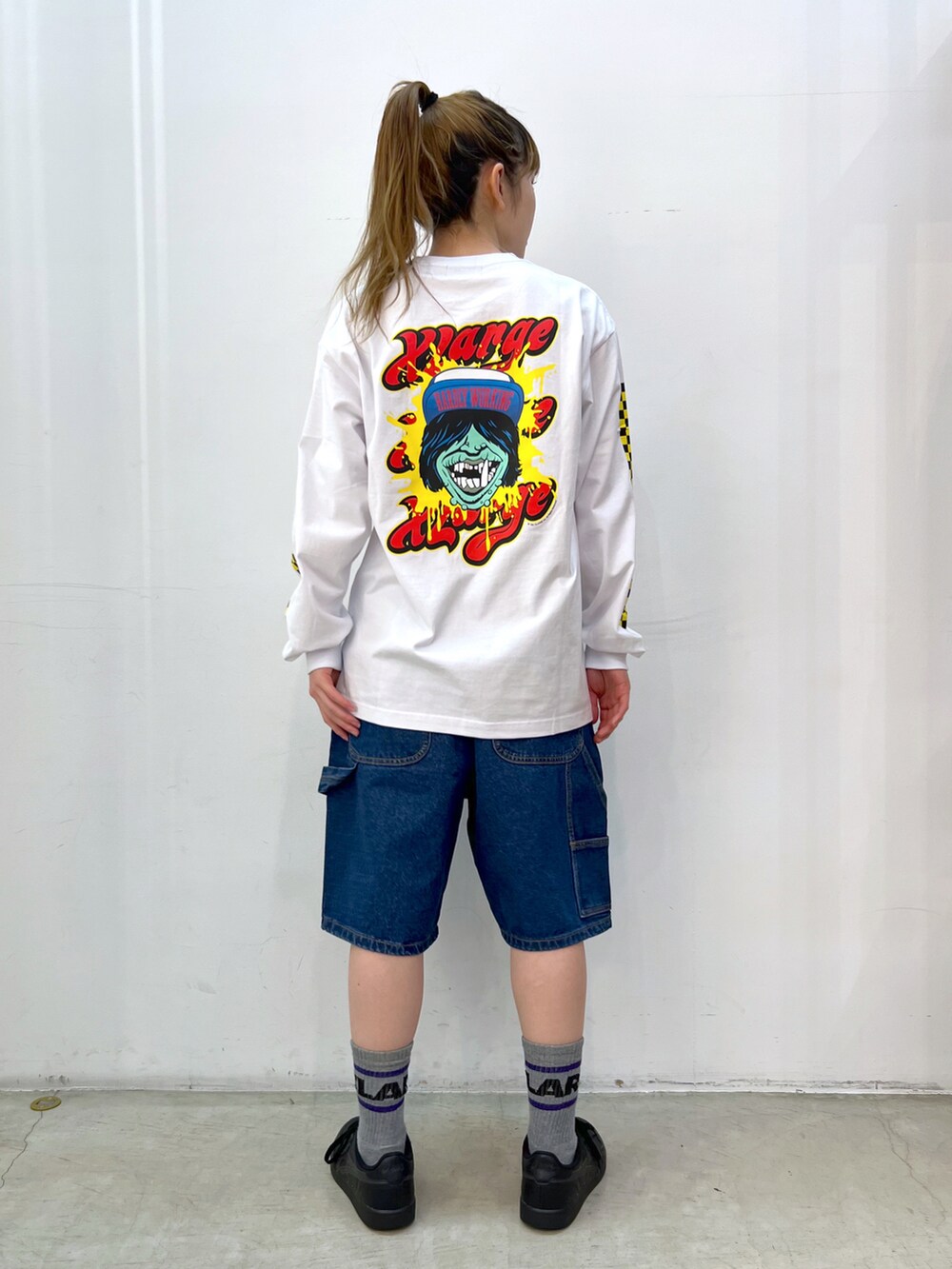 イエロー系のベスト、ホワイト系のTシャツ/カットソー、ブルー系のデニムパンツを着用したレディースの春コーディネートの3枚目の写真