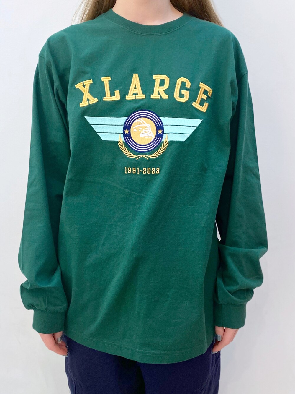 グリーン系のTシャツ/カットソー、ブルー系のその他パンツ、グリーン系のキャップを着用したレディースの春コーディネートの2枚目の写真