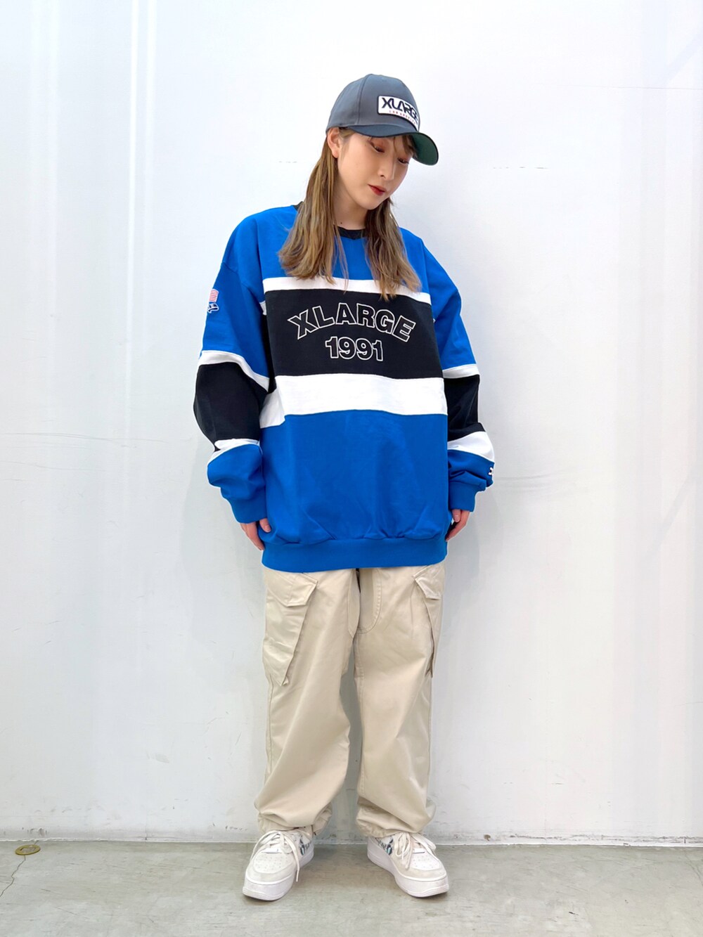 ブルー系のTシャツ/カットソー、ベージュ系のその他パンツ、ブラック系のキャップを着用したレディースの春コーディネートの2枚目の写真