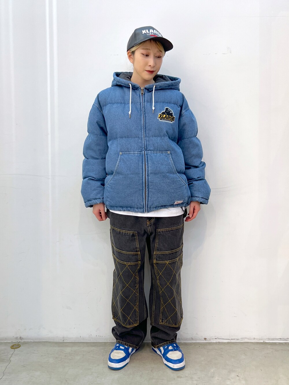 ブルー系のブルゾン、ホワイト系のTシャツ/カットソー、ブラック系のデニムパンツを着用したレディースの冬コーディネートの3枚目の写真