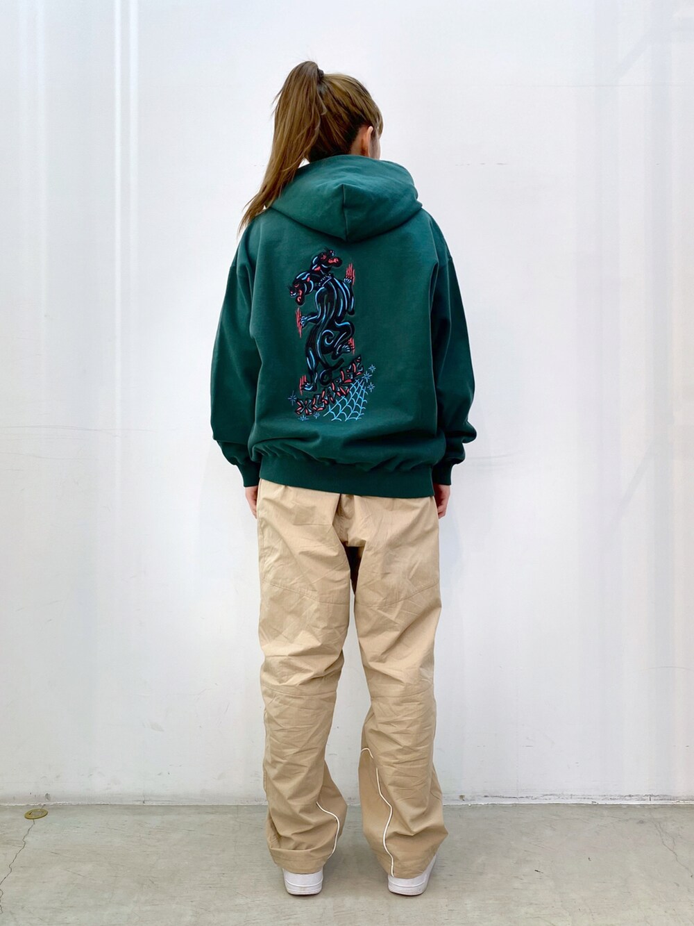 グリーン系のパーカー、ベージュ系のその他パンツを着用したレディースの冬コーディネートの2枚目の写真