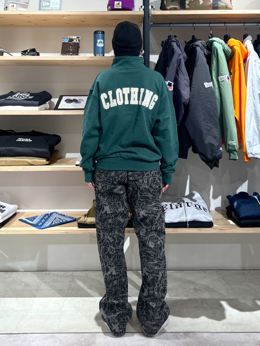 グリーン系のスウェット、ブラック系のデニムパンツ、ブラック系のニットキャップ/ビーニーを着用したレディースの冬コーディネートの2枚目の写真