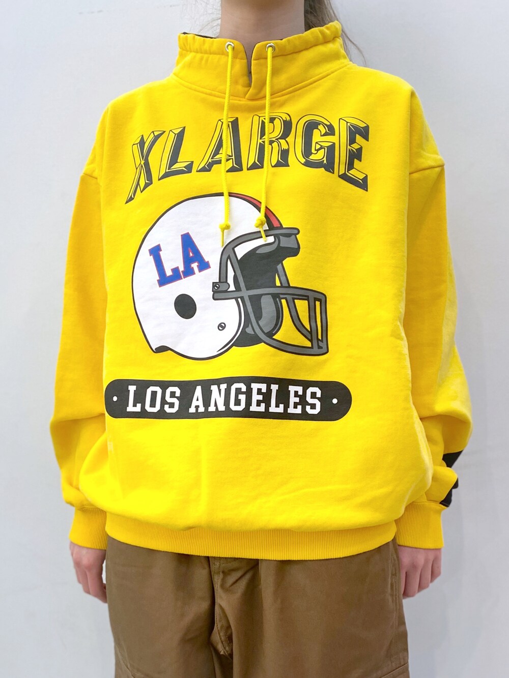 イエロー系のスウェット、ベージュ系のその他パンツを着用したレディースの春コーディネートの3枚目の写真