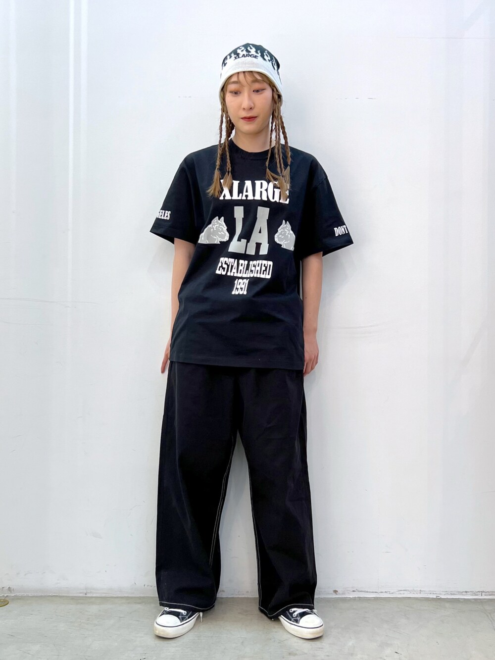 ブラック系のTシャツ/カットソー、ブラック系のその他パンツ、ホワイト系のキャップを着用したレディースの春コーディネートの2枚目の写真