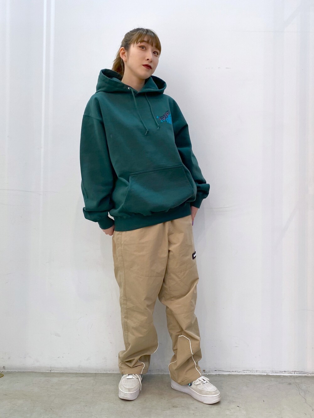 グリーン系のパーカー、ベージュ系のその他パンツを着用したレディースの冬コーディネートの3枚目の写真