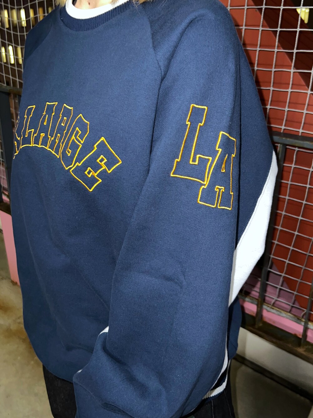 ブルー系のスウェット、ブルー系のデニムパンツ、ブラック系のキャップを着用したレディースの冬コーディネートの4枚目の写真