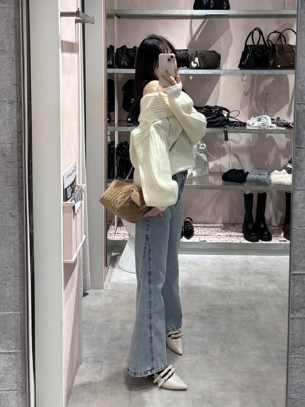 ホワイト系のニット/セーター、ブルー系のデニムパンツ、ホワイト系のパンプスを着用したレディースの冬コーディネートの3枚目の写真