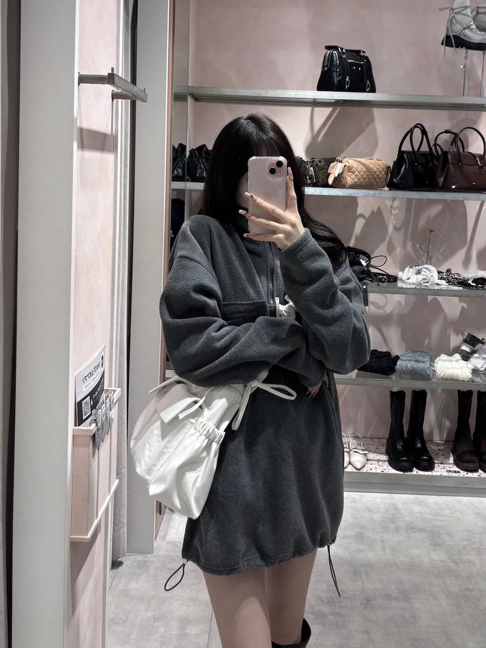 ブラック系のブーツ、グレー系のワンピース、ホワイト系のショルダーバッグを着用したレディースの冬コーディネートの7枚目の写真