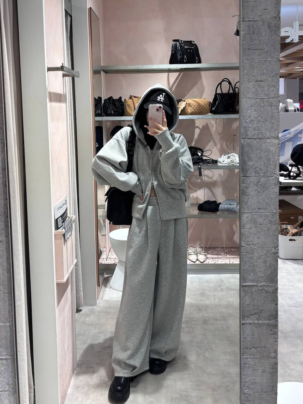 ブラック系のショルダーバッグ、グレー系のパーカー、グレー系のスウェットパンツを着用したレディースの冬コーディネートの6枚目の写真