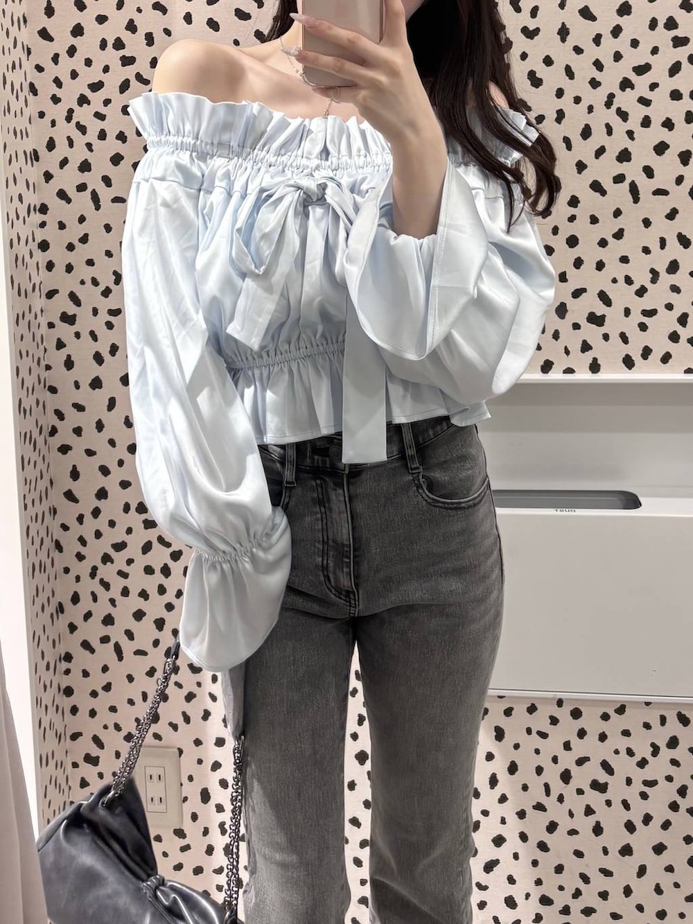 グレー系のショルダーバッグ、グレー系のデニムパンツ、ブラック系のパンプスを着用したレディースの春コーディネートの2枚目の写真