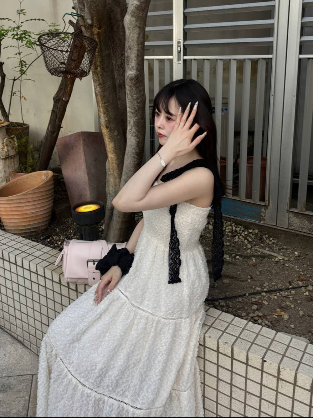 ブラック系のパンプス、ホワイト系のチューブトップ、ホワイト系のワンピースを着用したレディースの春コーディネートの2枚目の写真