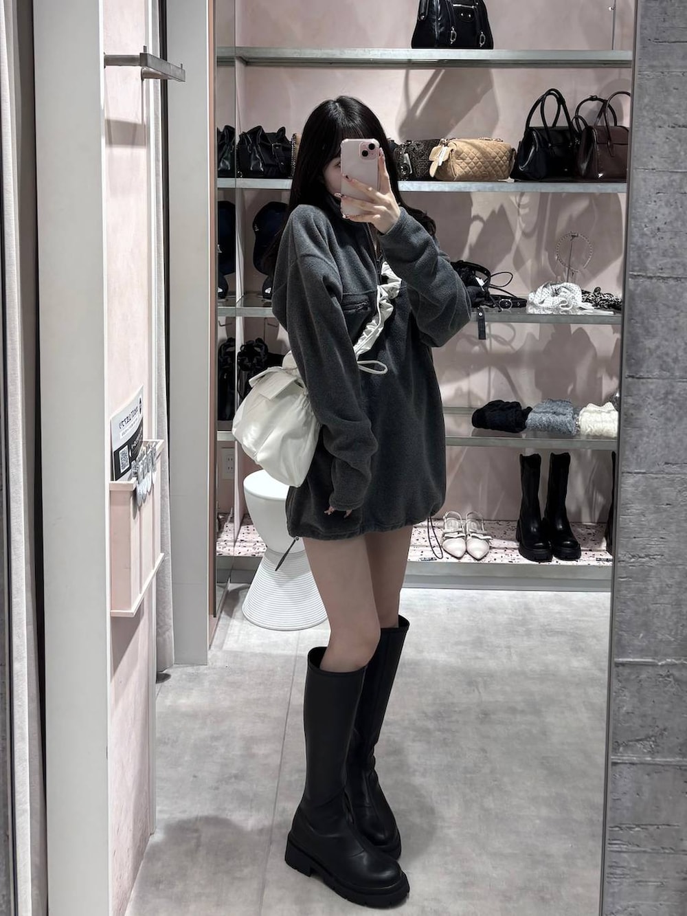 ブラック系のブーツ、グレー系のワンピース、ホワイト系のショルダーバッグを着用したレディースの冬コーディネートの5枚目の写真