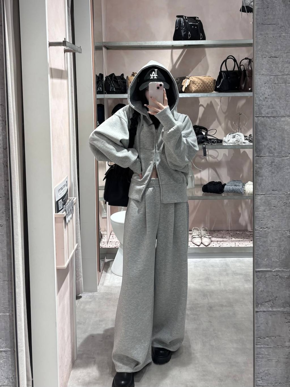 ブラック系のショルダーバッグ、グレー系のパーカー、グレー系のスウェットパンツを着用したレディースの冬コーディネートの5枚目の写真