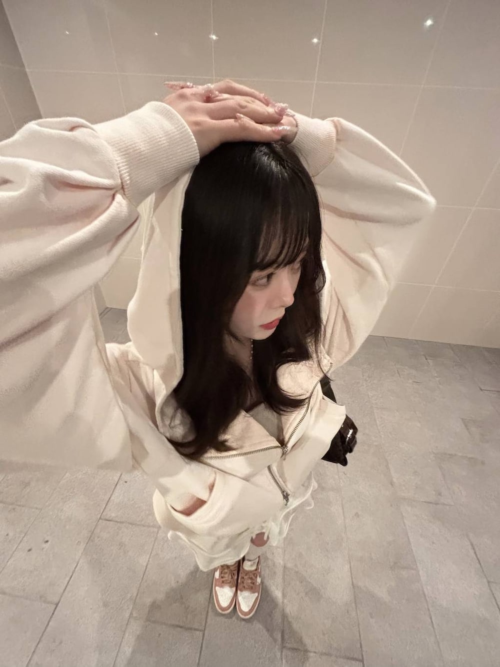 ホワイト系のキャミソール、ピンク系のパーカーを着用したレディースの春コーディネートの3枚目の写真