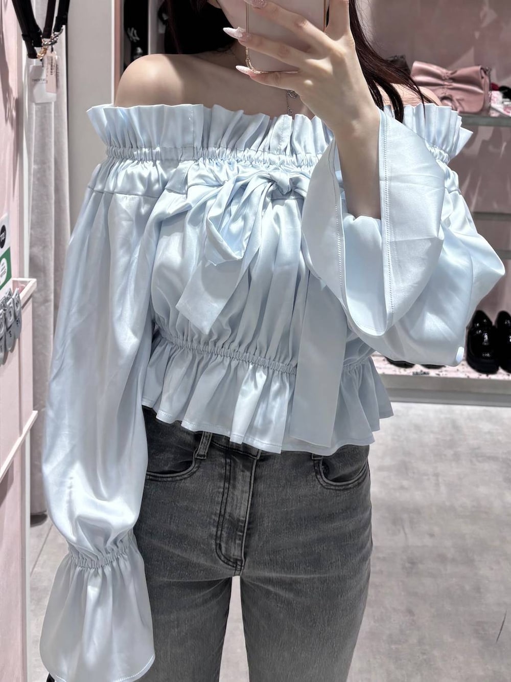 グレー系のショルダーバッグ、グレー系のデニムパンツ、ブラック系のパンプスを着用したレディースの春コーディネートの4枚目の写真