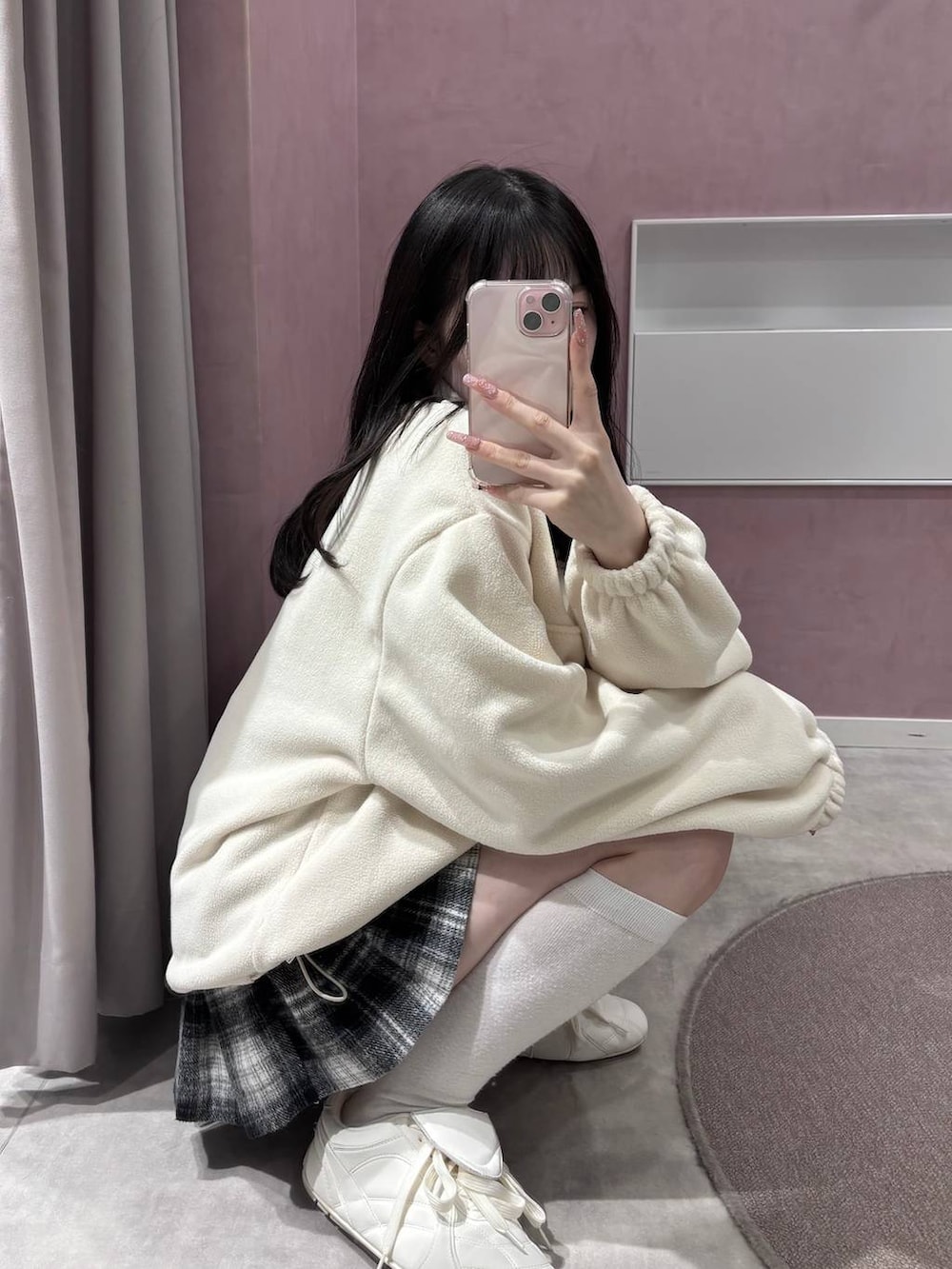 ホワイト系のスニーカー、ブラック系のスカート、ホワイト系のスウェットを着用したレディースの冬コーディネートの10枚目の写真