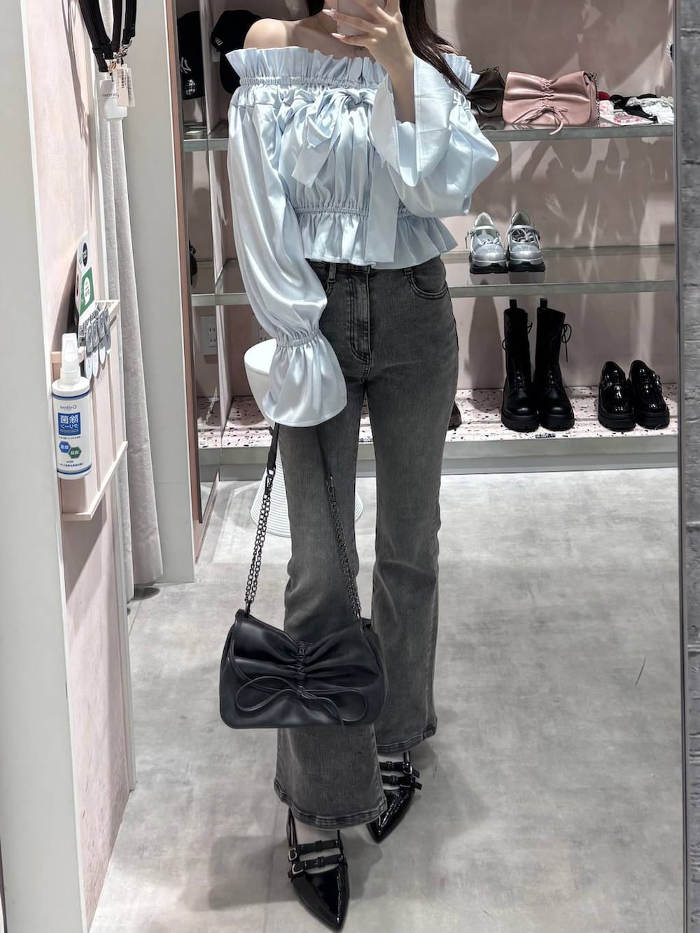 グレー系のショルダーバッグ、グレー系のデニムパンツ、ブラック系のパンプスを着用したレディースの春コーディネートの5枚目の写真