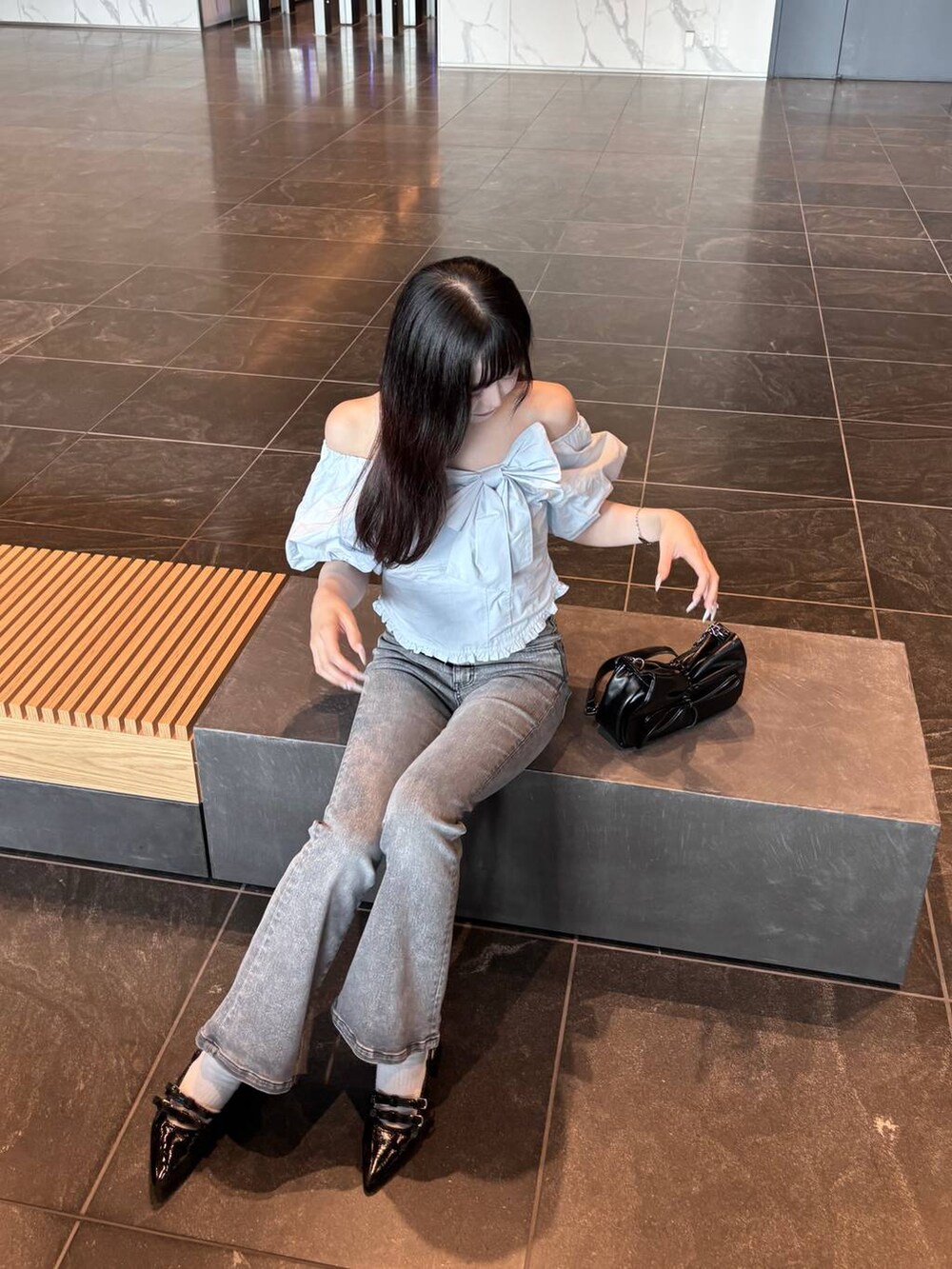 ブルー系のシャツ/ブラウス、ブラック系のショルダーバッグ、グレー系のデニムパンツを着用したレディースの夏コーディネートの5枚目の写真