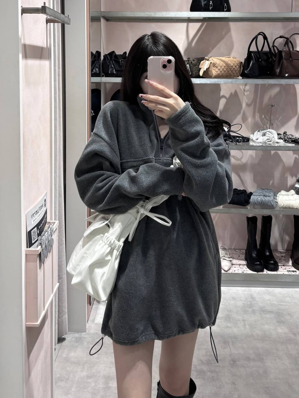 ブラック系のブーツ、グレー系のワンピース、ホワイト系のショルダーバッグを着用したレディースの冬コーディネートの4枚目の写真