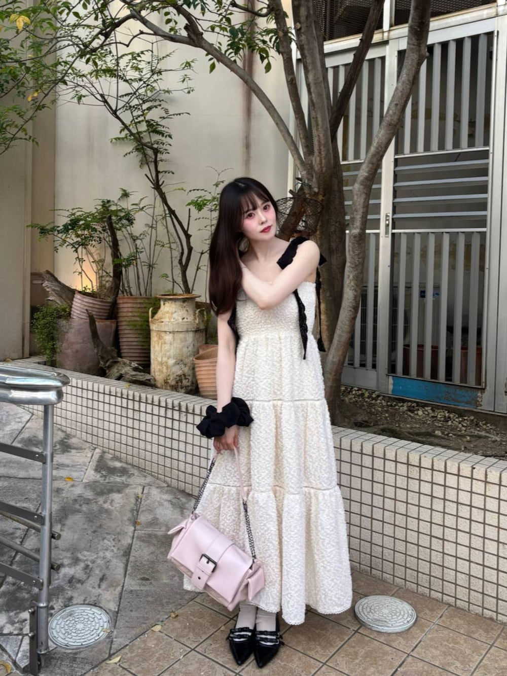 ブラック系のパンプス、ホワイト系のチューブトップ、ホワイト系のワンピースを着用したレディースの春コーディネートの8枚目の写真