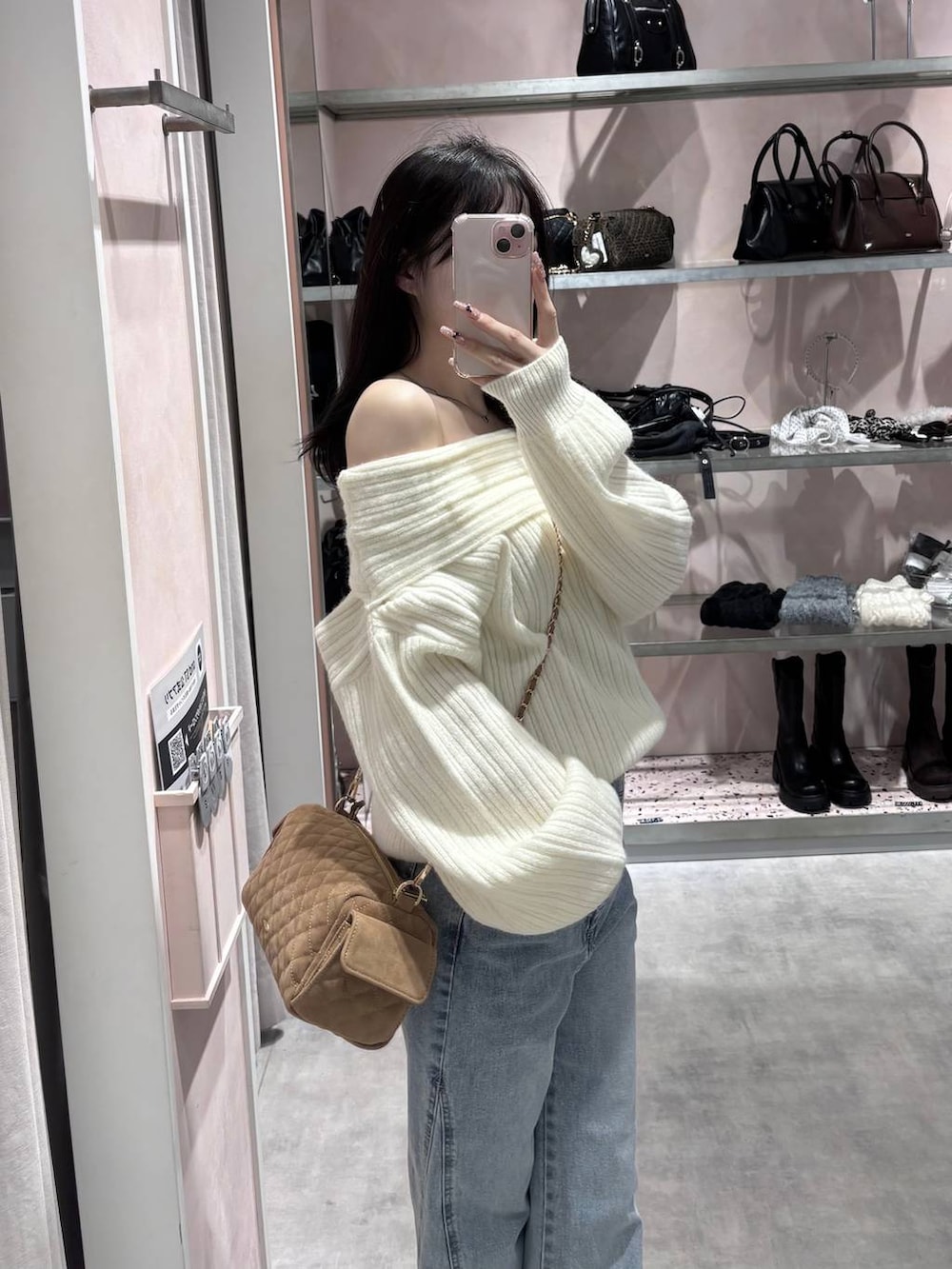 ホワイト系のニット/セーター、ブルー系のデニムパンツ、ホワイト系のパンプスを着用したレディースの冬コーディネートの4枚目の写真