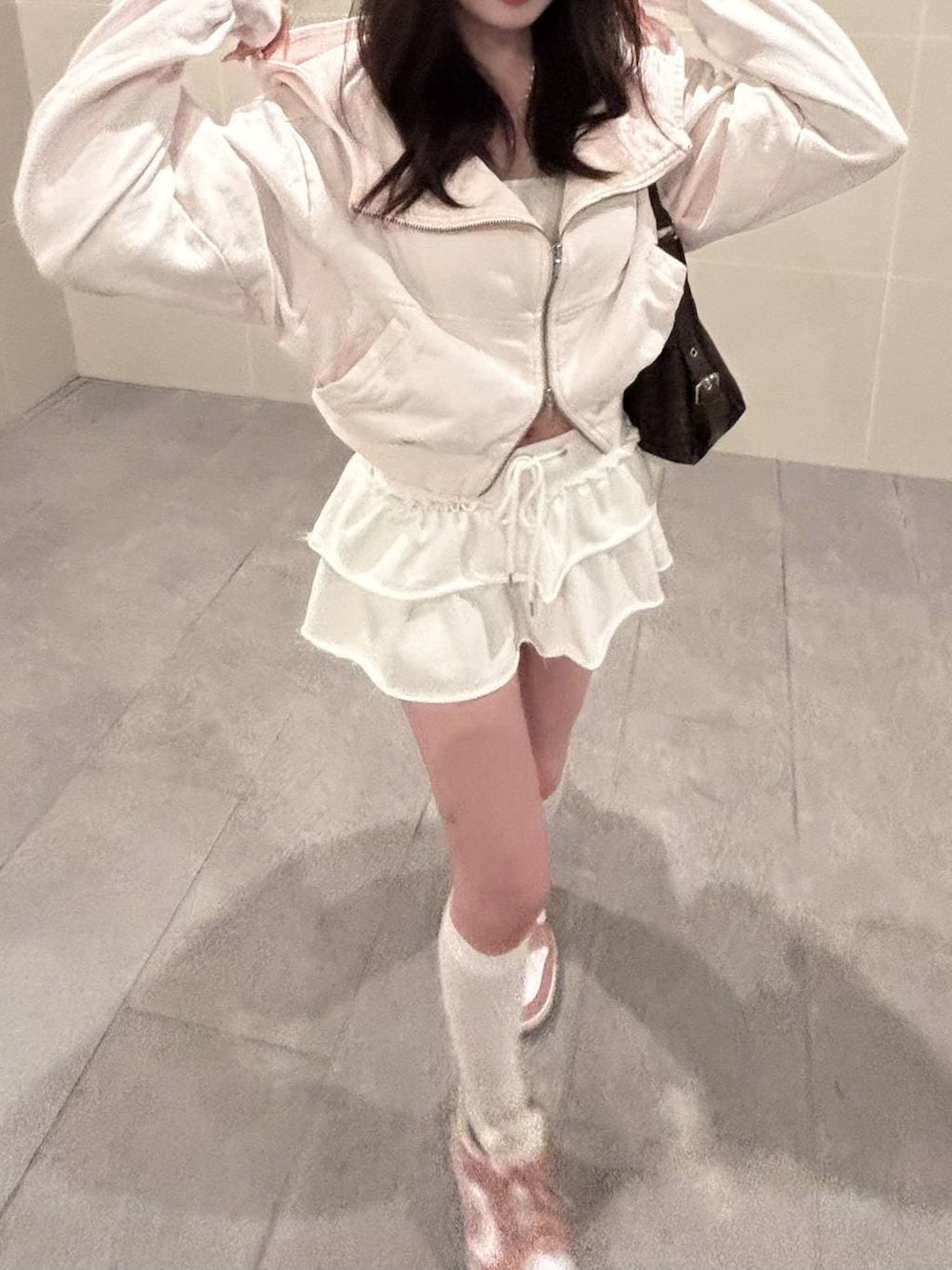 ホワイト系のキャミソール、ピンク系のパーカーを着用したレディースの春コーディネートの2枚目の写真