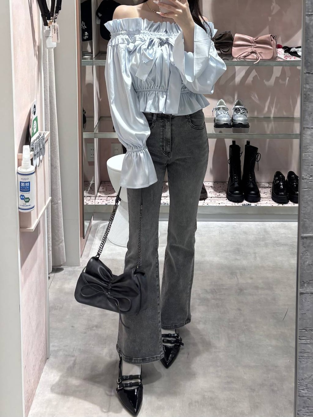 グレー系のショルダーバッグ、グレー系のデニムパンツ、ブラック系のパンプスを着用したレディースの春コーディネートの3枚目の写真