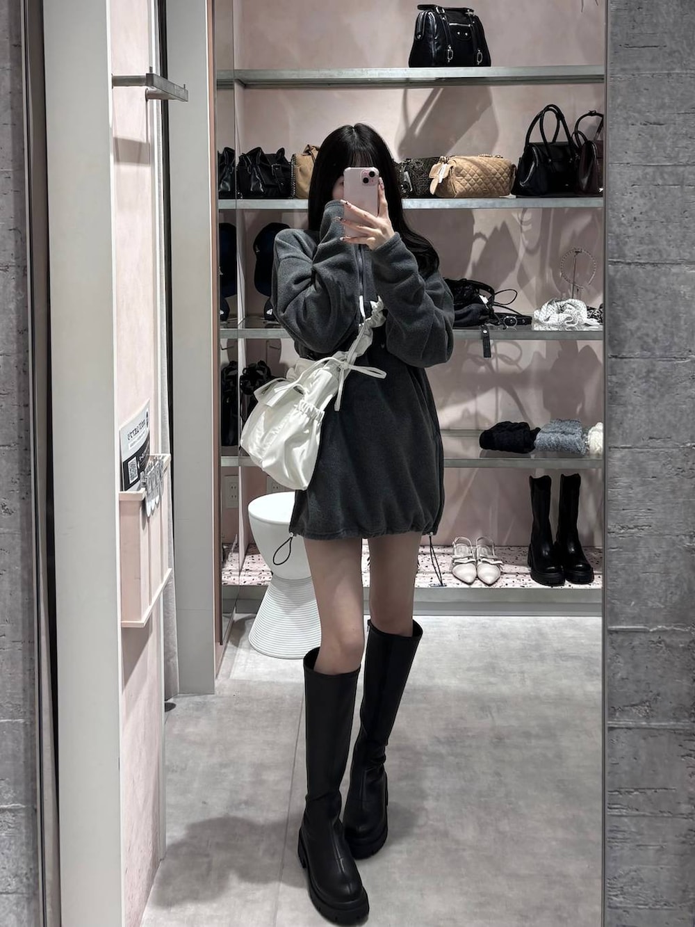 ブラック系のブーツ、グレー系のワンピース、ホワイト系のショルダーバッグを着用したレディースの冬コーディネートの10枚目の写真