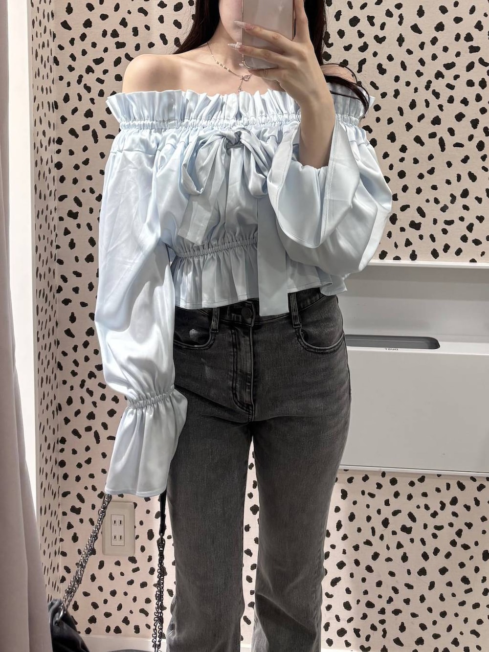 グレー系のショルダーバッグ、グレー系のデニムパンツ、ブラック系のパンプスを着用したレディースの春コーディネートの7枚目の写真