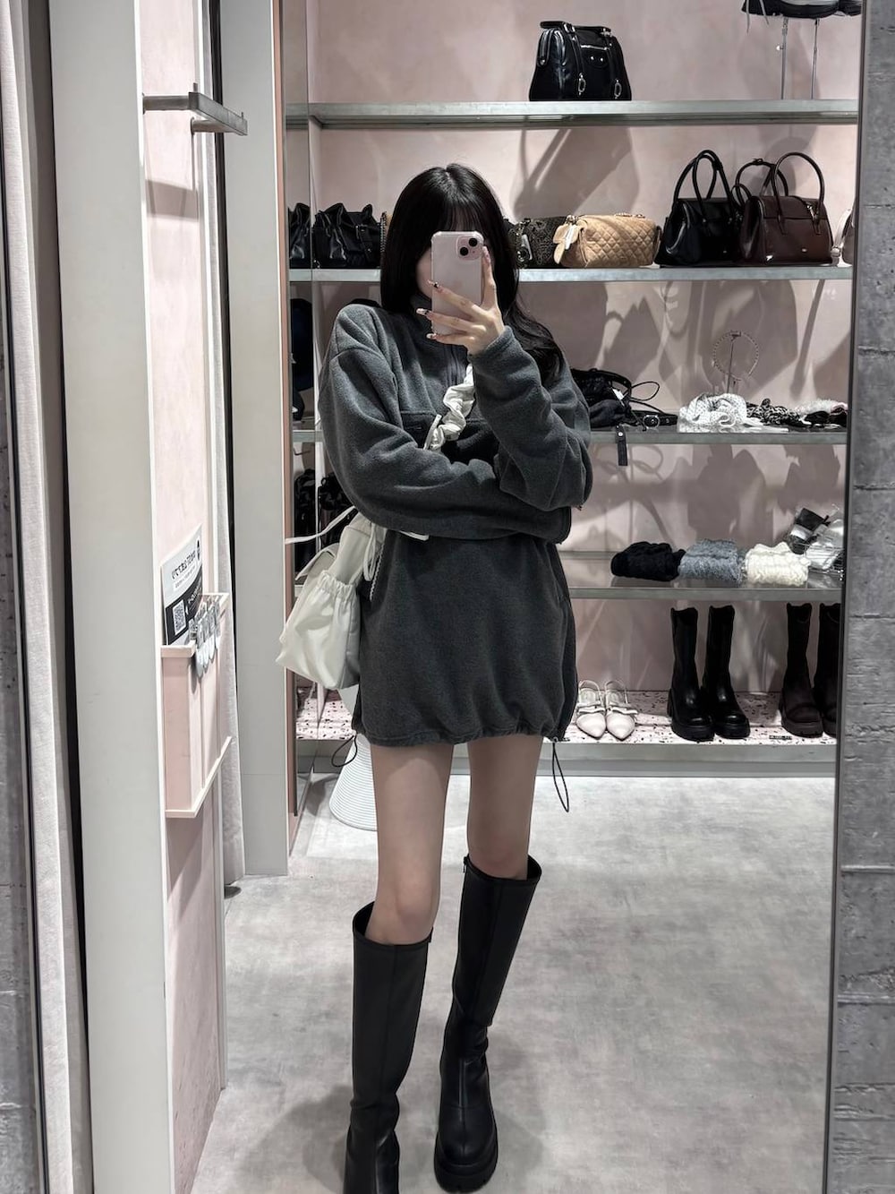 ブラック系のブーツ、グレー系のワンピース、ホワイト系のショルダーバッグを着用したレディースの冬コーディネートの9枚目の写真