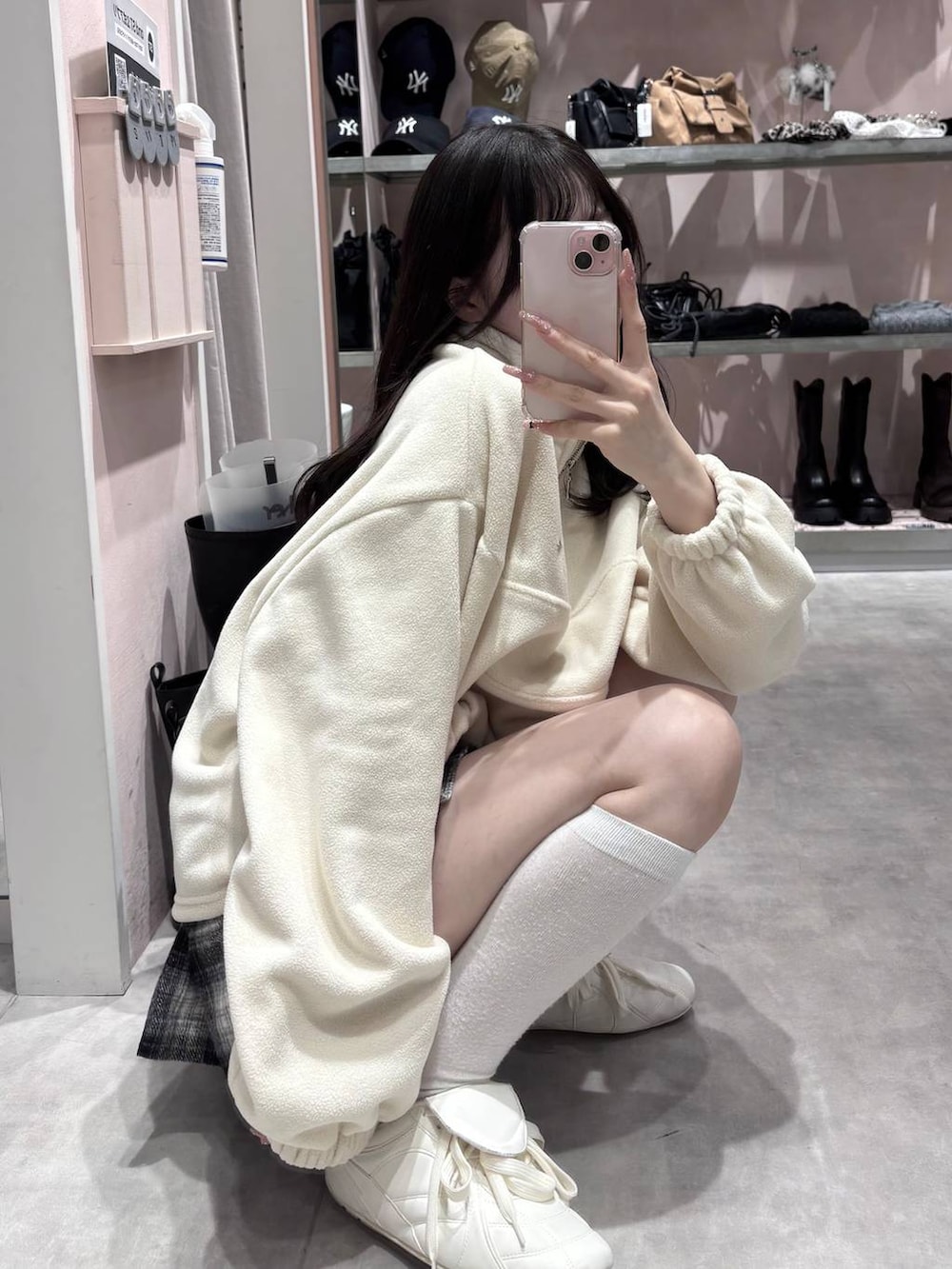 ホワイト系のスニーカー、ブラック系のスカート、ホワイト系のスウェットを着用したレディースの冬コーディネートの5枚目の写真