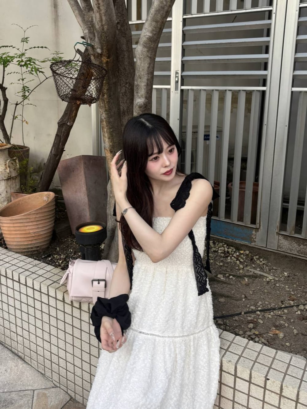 ブラック系のパンプス、ホワイト系のチューブトップ、ホワイト系のワンピースを着用したレディースの春コーディネートの5枚目の写真