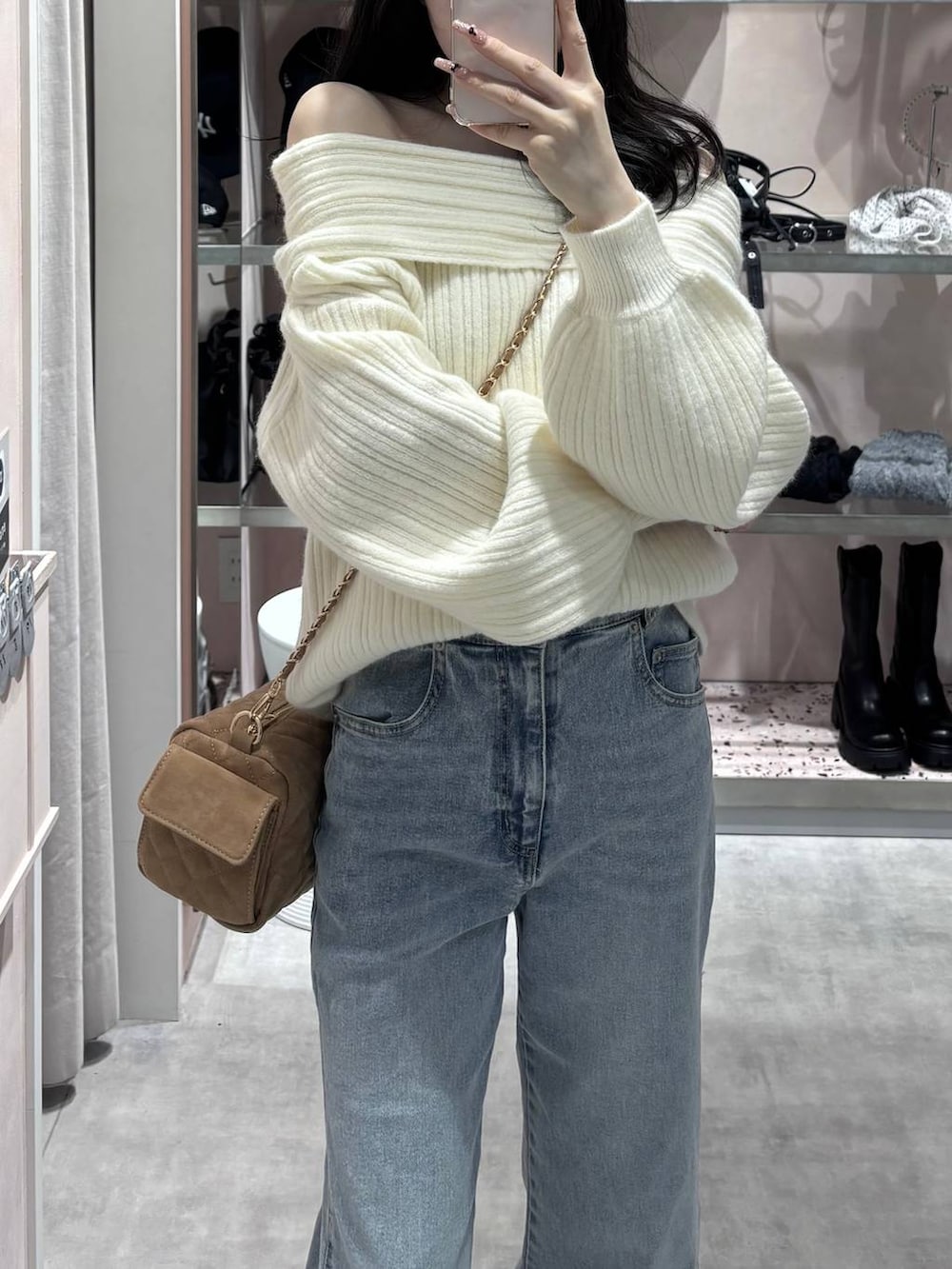 ホワイト系のニット/セーター、ブルー系のデニムパンツ、ホワイト系のパンプスを着用したレディースの冬コーディネートの6枚目の写真