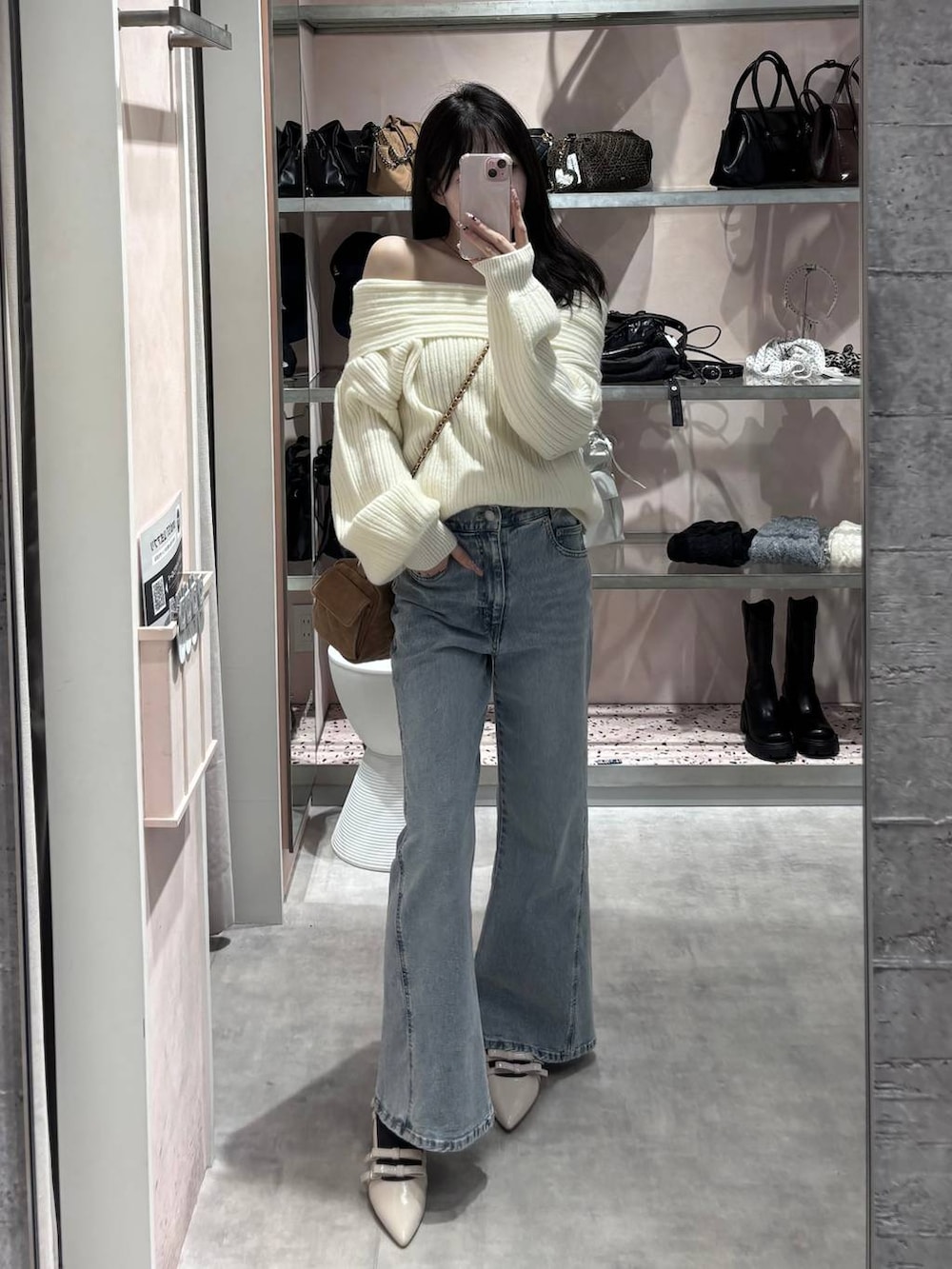 ホワイト系のニット/セーター、ブルー系のデニムパンツ、ホワイト系のパンプスを着用したレディースの冬コーディネートの9枚目の写真