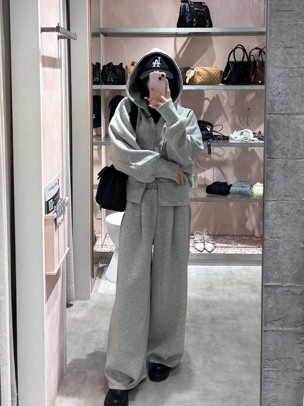 ブラック系のショルダーバッグ、グレー系のパーカー、グレー系のスウェットパンツを着用したレディースの冬コーディネートの9枚目の写真