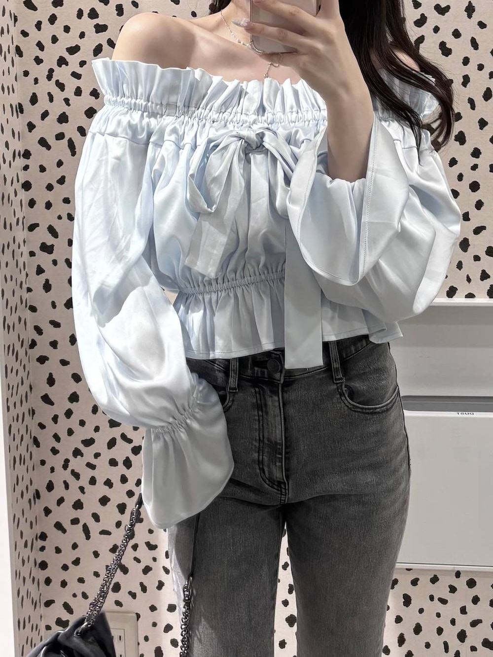 グレー系のショルダーバッグ、グレー系のデニムパンツ、ブラック系のパンプスを着用したレディースの春コーディネートの6枚目の写真