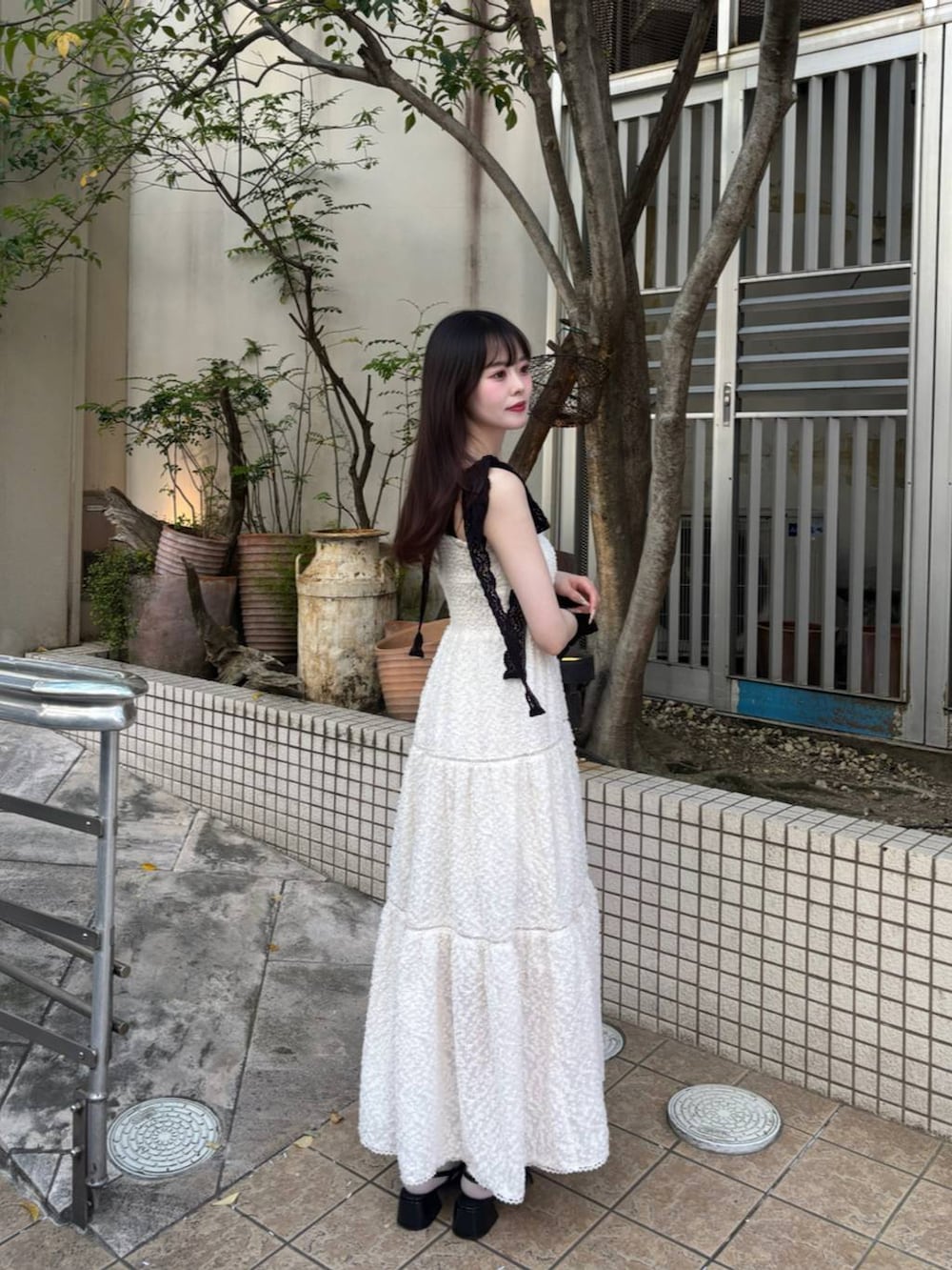 ブラック系のパンプス、ホワイト系のチューブトップ、ホワイト系のワンピースを着用したレディースの春コーディネートの7枚目の写真
