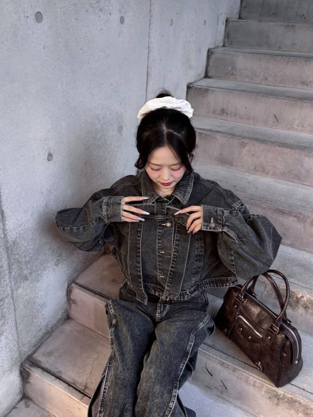 ブラウン系のボストンバッグ、ブラック系のパンプス、ブラック系のデニムジャケットを着用したレディースの冬コーディネートの8枚目の写真